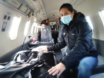 A woman inside a medevac lear jet, next to a stretcher