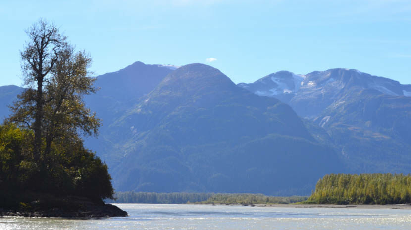 A wide river with mountains in the background