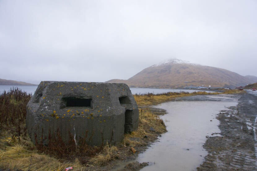 An abandoned concrete pillbox with a mountain in the background