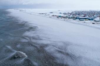 An aerial shot of Utqiagvik in the snow, taken from just off the coast