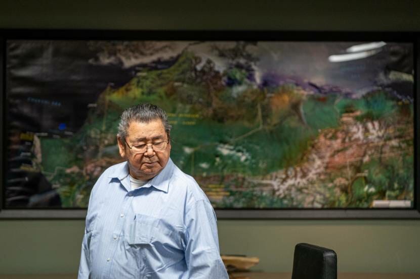 A man standing in front of a large wall map of the North Slope