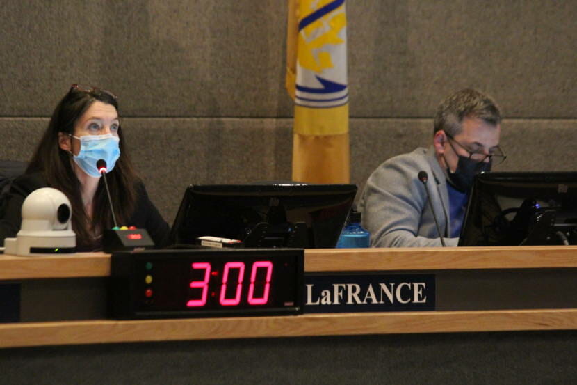 Two masked assembly members behind a desk