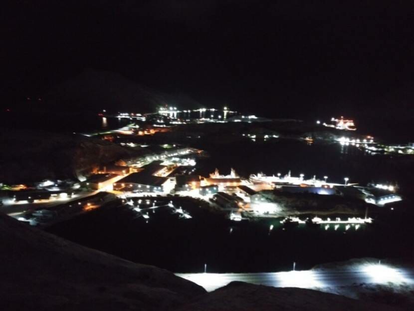 A view of harbor and city lights from above, in the dark