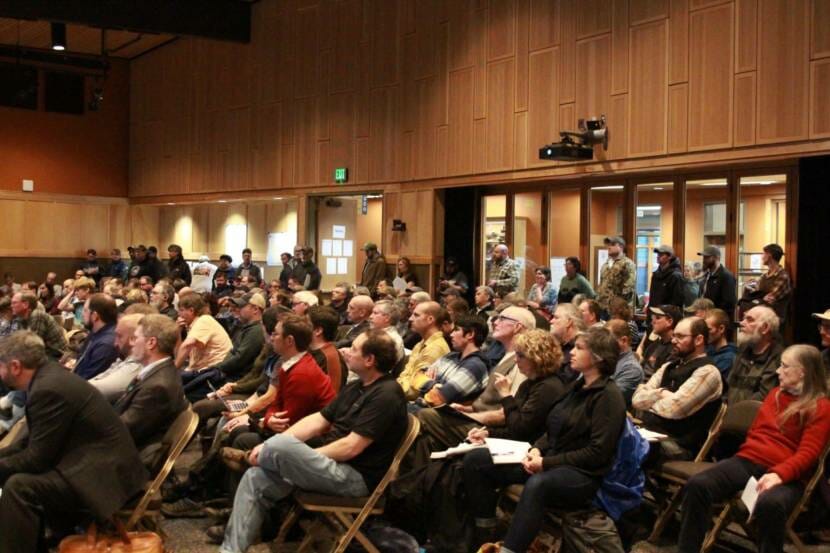 An auditorium or large meeting room filled with seated people