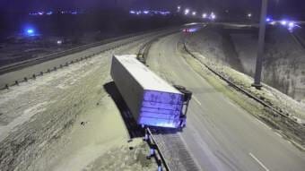 A tractor-trailer lying on its side on a highway at night