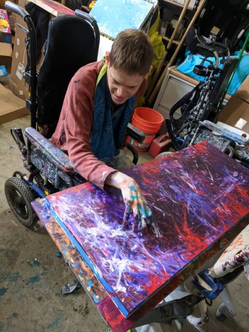 Avery Skaggs is a Juneau artist who is non-verbal and uses a wheelchair. His hand movement is limited, but he paints with his fingers. 