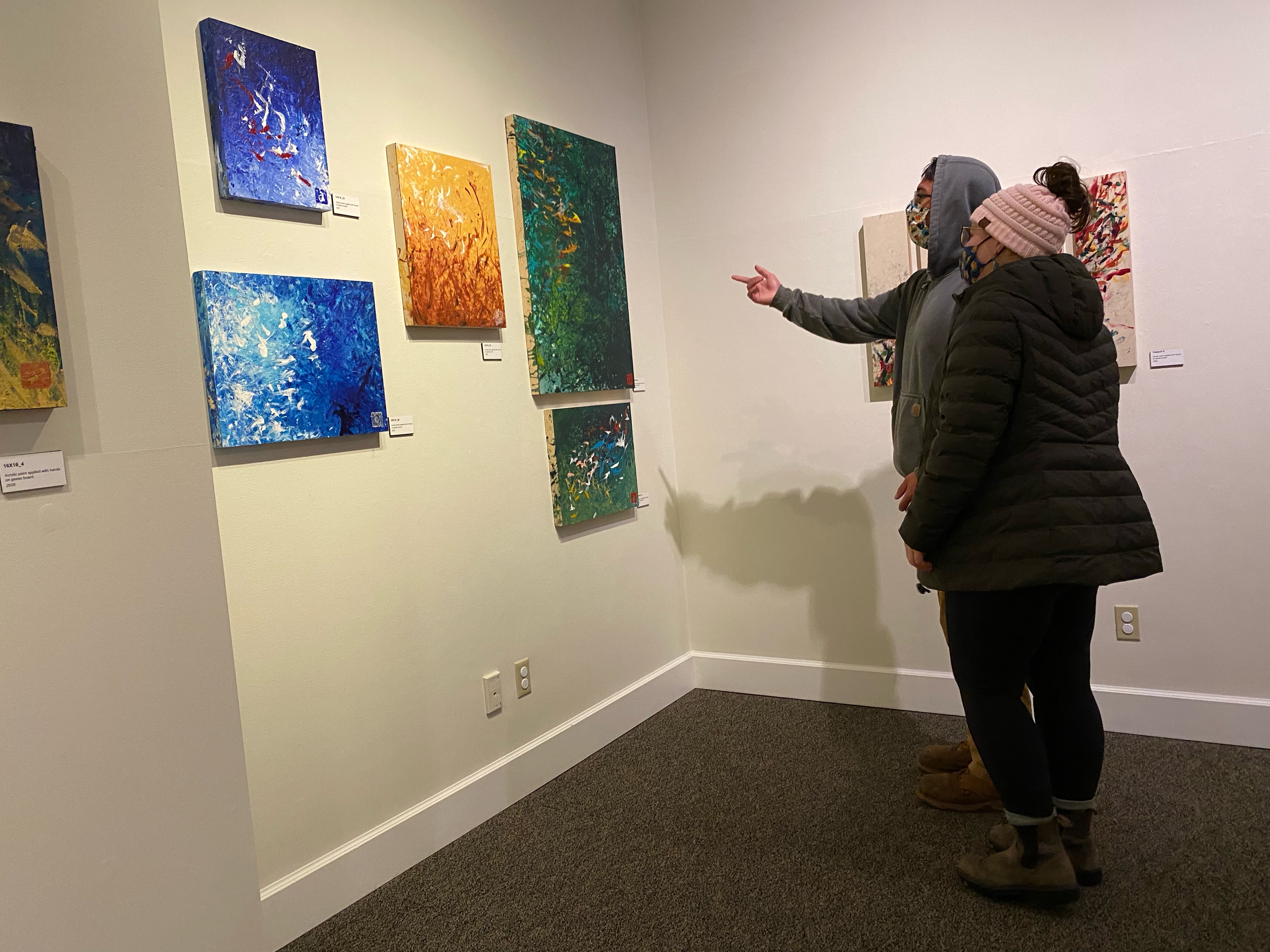 Museum-goers examine the artwork of Avery Skaggs at the Juneau-Douglas City Museum on Friday, Jan. 7 2022.