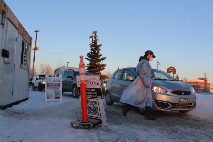 A health worker approaches a car at a COVID testing site