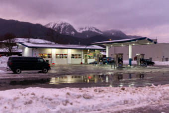 A gas station in the snow with mountains behind it