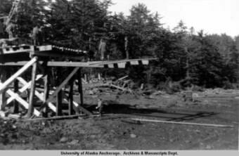 A black and white photo showing two men building a dock