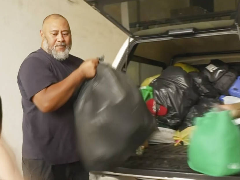 A man unloading bagged donations from the back of an SUV