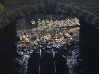 Emergency officials are seen through a CSX railroad tunnel near debris that fell onto tracks in the Charles Village neighborhood of Baltimore.