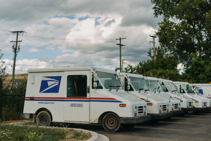 USPS trucks parked in a line