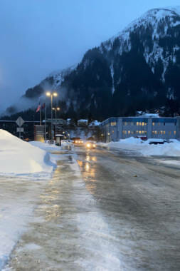 a road completely coated in thick ice with a mountain in the background