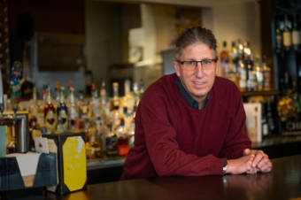 Photo portrait of a man standing behind a bar