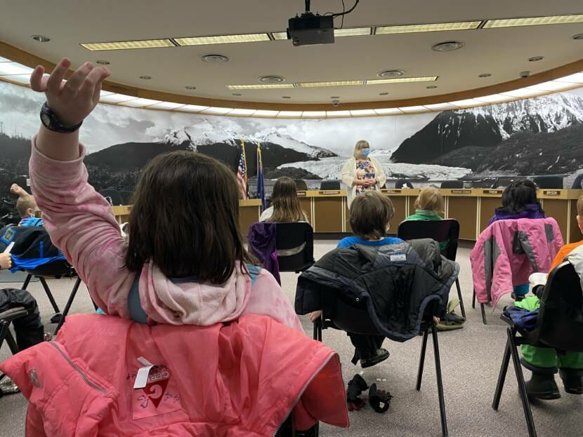 A second grade student raises her hand to ask Juneau Mayor Beth Weldon a question on Friday, Feb. 4, 2022.