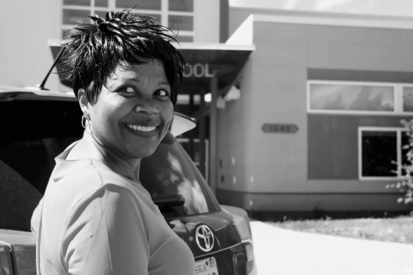 Black-and-white image of a woman smiling as she walks