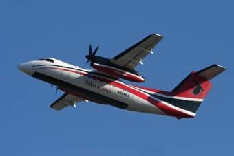 A twin-engine Ravn Alaska plane gaining altitude after takeoff