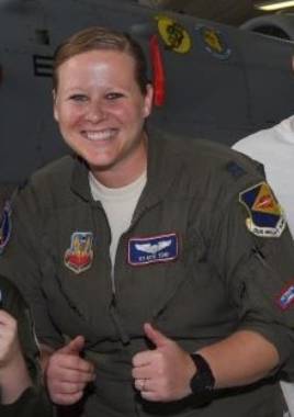 A woman in uniform giving a double thumbs-up