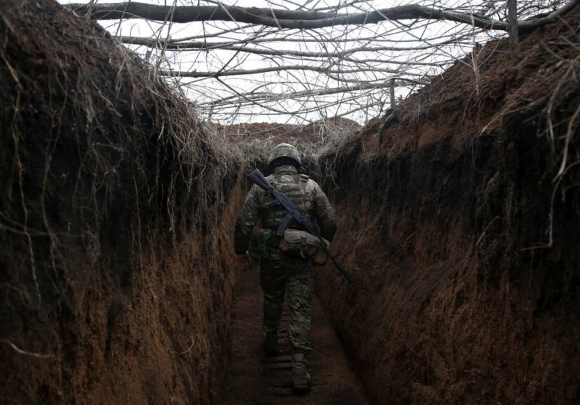 A soldier walking through a trench