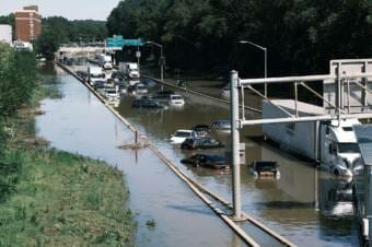 cars and trucks half-submerged on a flooded highway