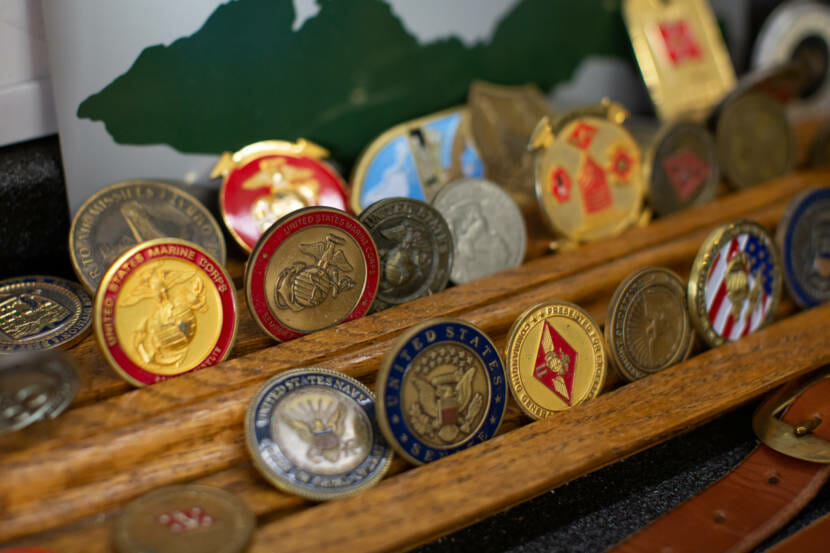 A wooden rack with commemorative coins on it.