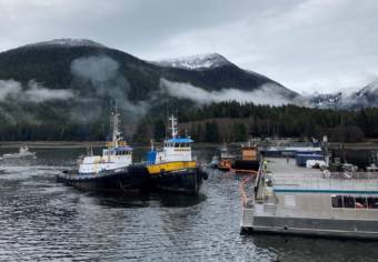 A pair of tugboats approaching a dock