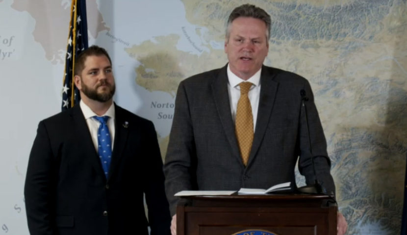 Adam Crum, commissioner of the Alaska Department of Health and Social Services, listens as Gov. Mike Dunleavy talks about the division of the agency into two smaller departments on March 21, 2022, in the Atwood Building in Anchorage. The Department of Health and the Department of Family and Community Services will be reorganized on July 1, 2022. (Screen capture of Dunleavy livestream)