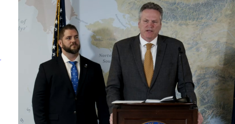 Adam Crum, commissioner of the Alaska Department of Health and Social Services, listens as Gov. Mike Dunleavy talks about the division of the agency into two smaller departments on March 21, 2022, in the Atwood Building in Anchorage. The Department of Health and the Department of Family and Community Services will be reorganized on July 1, 2022. (Screen capture of Dunleavy livestream)