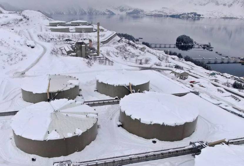A view from above of eight huge oil storage tanks with thick snow on top of them