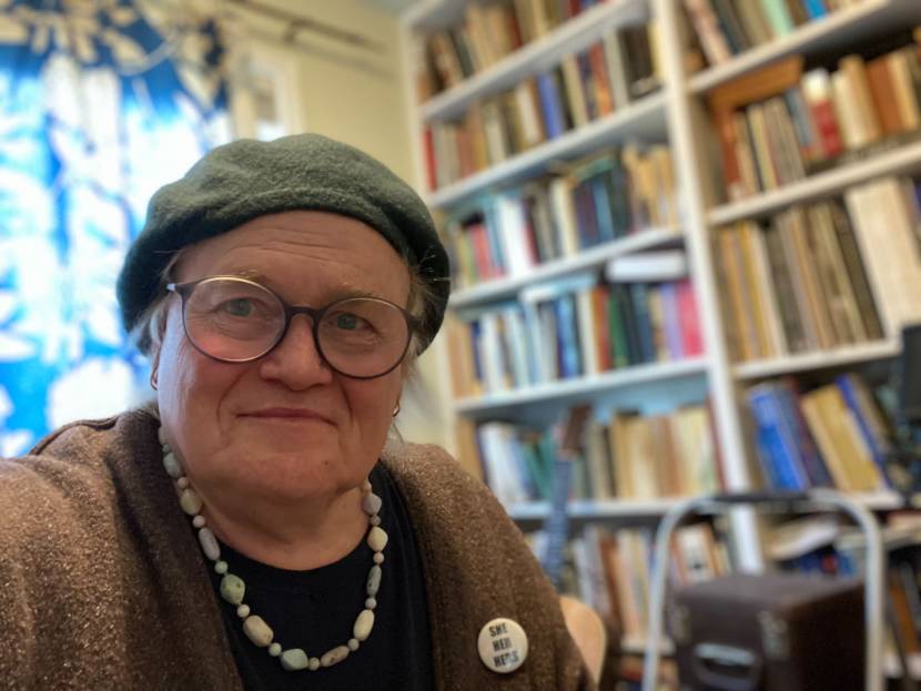 A portrait of Jane Hale with bookshelves in the background