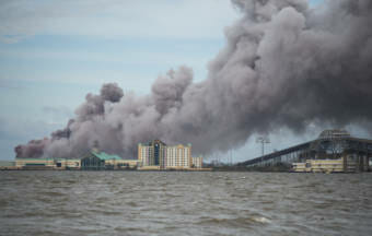 A chemical plant burning at the edge of a body of water