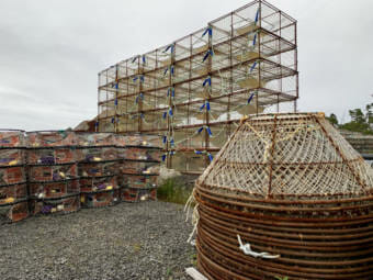 Three different kinds of crab pots stacked up on land