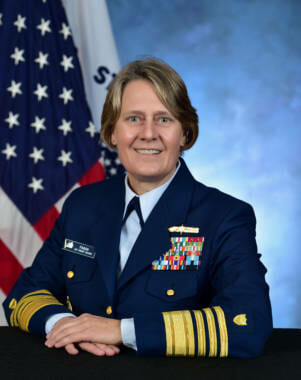 A formal Coast Guard portrait of Admiral Linda Fagan next to an American flag