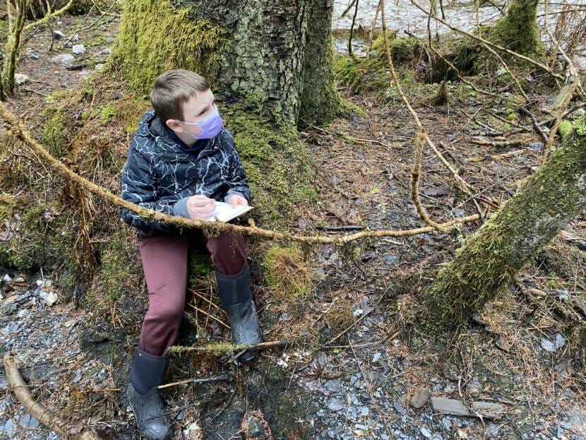 Juneau third grade student, Ben Catalioto draws what he sees in the forest on April 1, 2022.