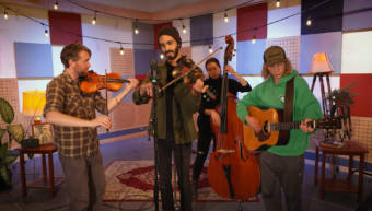 Jake Blount performs on a fiddle with bandmates at the KTOO studios during a Red Carpet Concert session
