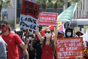 Demonstrators wearing red and carrying pro-labor signs