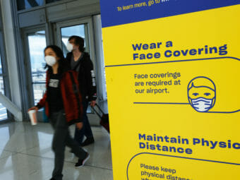 Masked passengers enter an airport