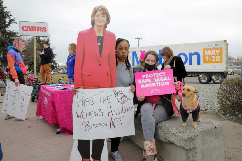 Abortion rights demonstrators pose with a cardboard cutout of Lisa Murkowski