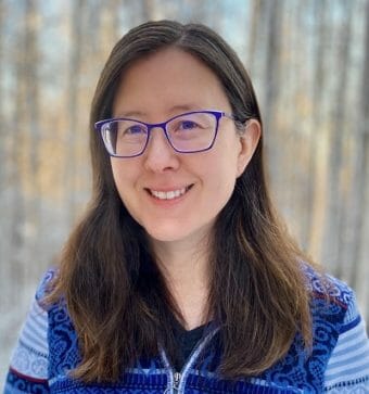 A headshot of a woman in glasses