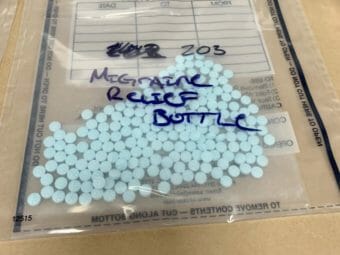 A bag of blue pills labeled "migraine relief bottle"