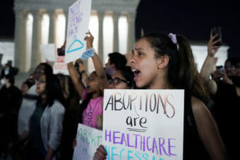 Demonstrators carrying signs with slogans like abortion is health care