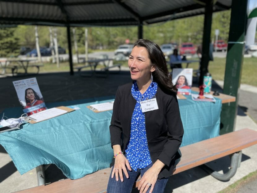 Mary Peltola sits on a bench at an outdoor event