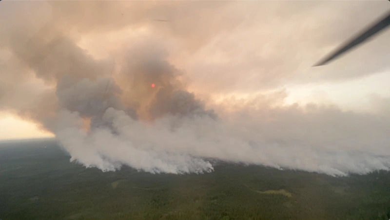 An aerial photo of a large wildfire burning in spruce forest