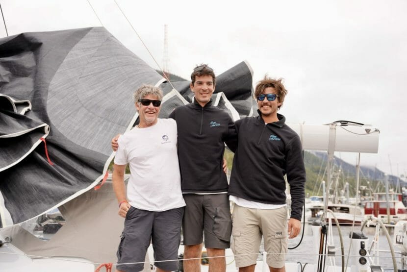 Three men on the deck of a sailboat