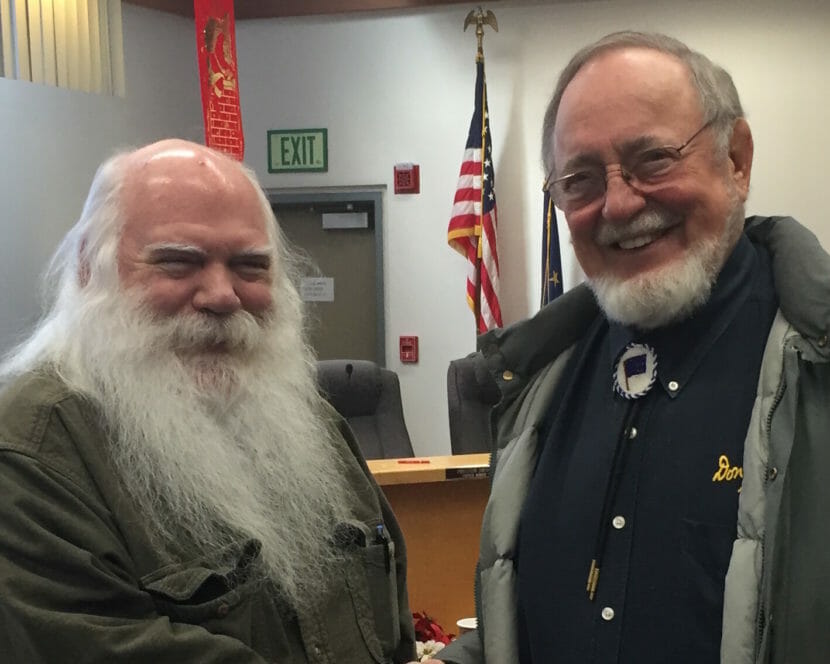 A man with a long white beard poses with Don Young