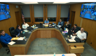 A city council meeting at a horseshoe-shaped table