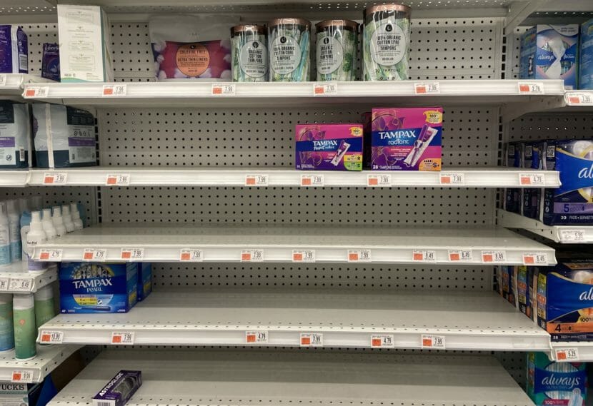 Mostly empty shore shelves in the tampon section