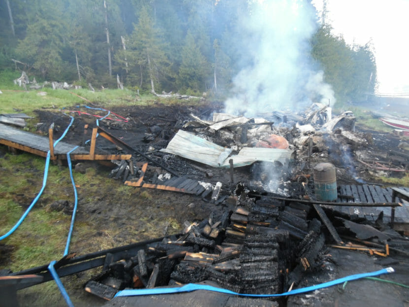 Smoke rising from what's left of a row of cabins