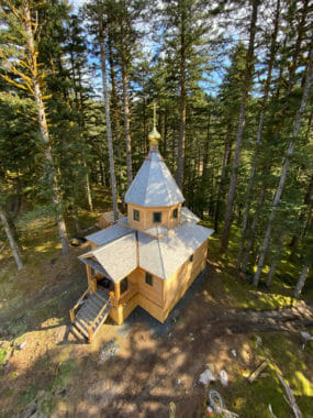 A small, wooden chapel with a gold dome, seen from above.